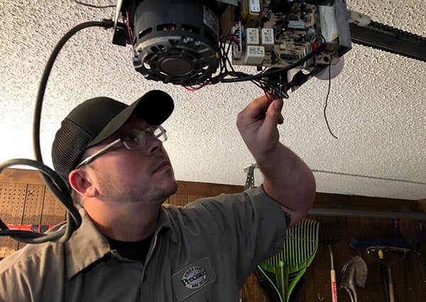 Precision Door Technician Inspecting Garage Door Opener