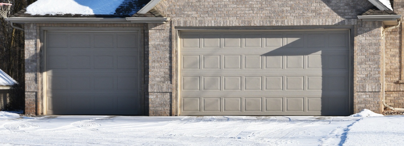 Garage door in winter with snow on driveway