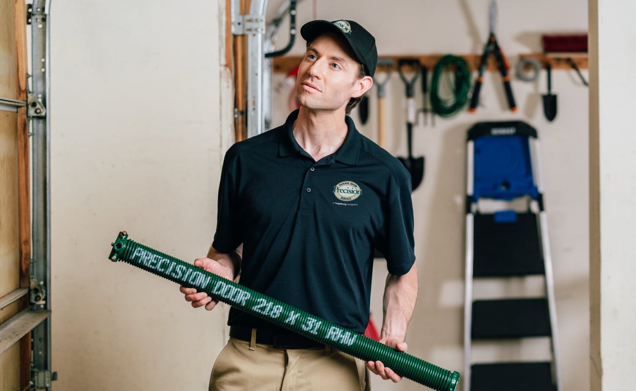 Precision Garage Door Service technician installing Precision new green garage door spring