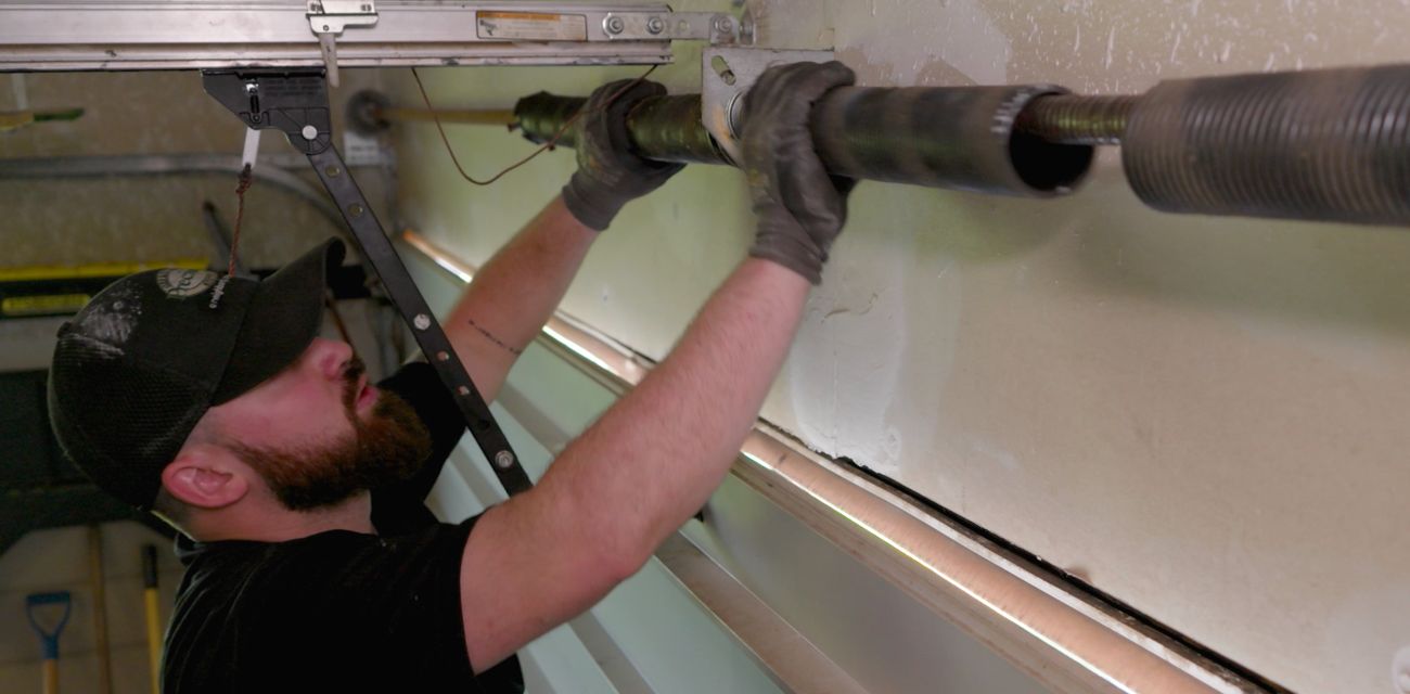 Precision Garage Door Service technician repairing garage door spring Precision Garage Door Service technician repairing garage door spring