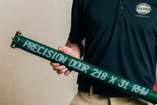 Precision Garage Door Service technician holding new Precision garage door spring