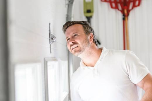 Man looking at interior of garage door.